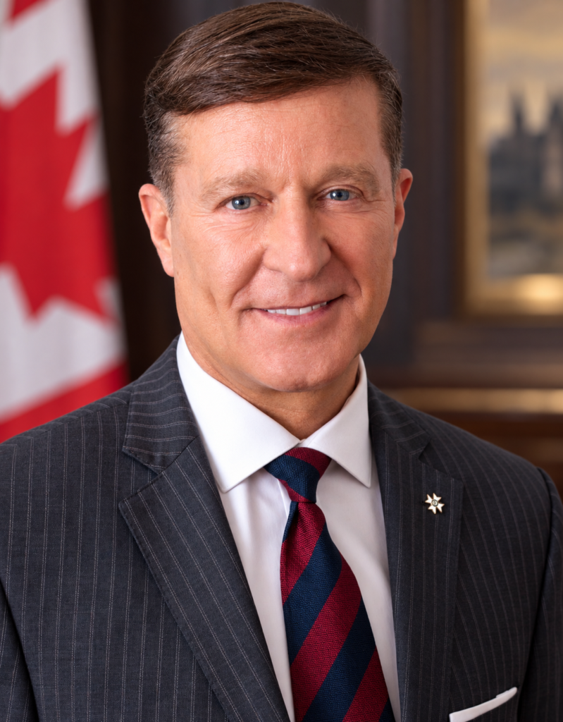 Bryan Brulotte in a suit with a Canadian flag in the background